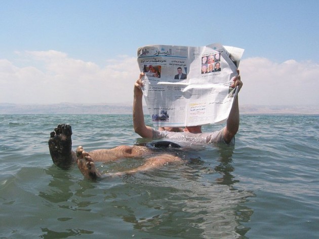 Turista lee el diario mientras flota en el Mar Muerto | Wikimedia Commons 
