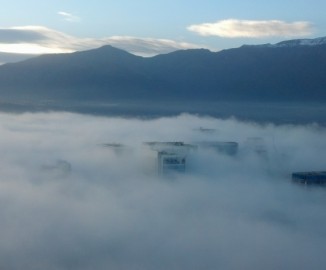 Imagen muestra edificio Costanera Center sobre la niebla en Santiago al amanecer