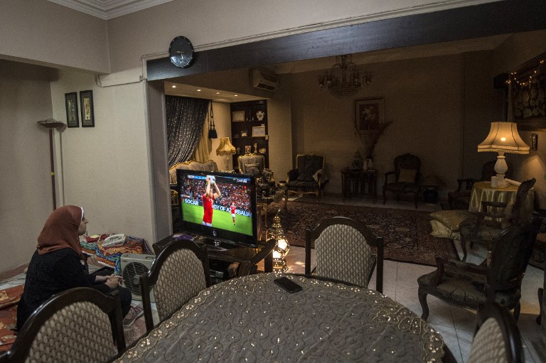 Football analyst Manar Sarhan watches the Euro 2016 quarter-final between Wales and Belgium at her home in the Egyptian capital Cairo on July 1, 2016. The 27-year-old woman who works as a dentist at a government medical centre appears weekly on the private CBC television channel to comment on matches in the competition, a rare sight in a field monopolised by former football players, all of them men. / AFP PHOTO / KHALED DESOUKI / TO GO WITH AFP STORY BY HAITHAM EL-TABEI