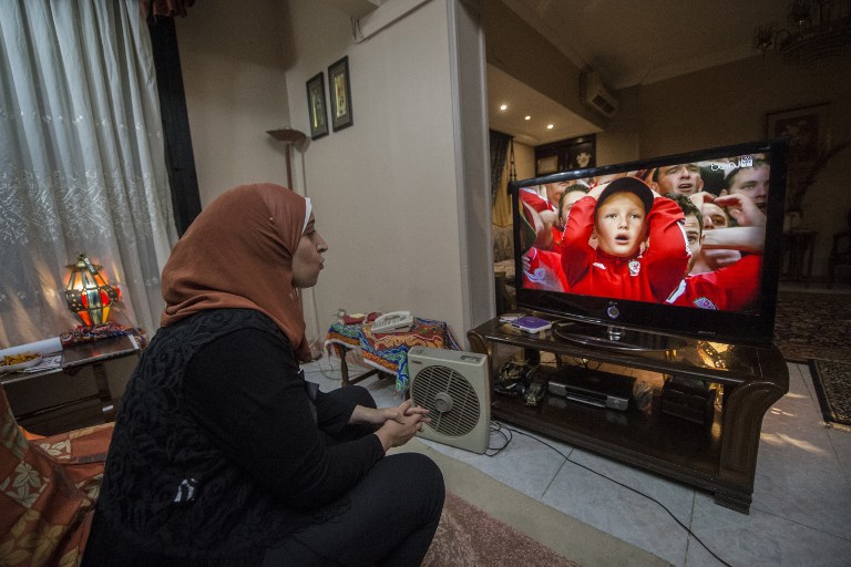 Football analyst Manar Sarhan watches the Euro 2016 quarter-final between Wales and Belgium at her home in the Egyptian capital Cairo on July 1, 2016. The 27-year-old woman who works as a dentist at a government medical centre appears weekly on the private CBC television channel to comment on matches in the competition, a rare sight in a field monopolised by former football players, all of them men. / AFP PHOTO / KHALED DESOUKI / TO GO WITH AFP STORY BY HAITHAM EL-TABEI