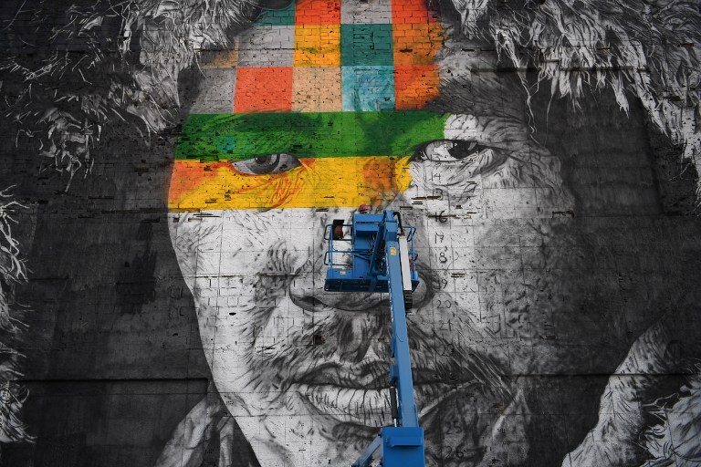 Assistants to Brazilian artist Eduardo Kobra work on the painting of a huge mural representing the five continents, at the Olympic Boulevard, in Rio de Janeiro, Brazil, on July 14, 2016. / AFP PHOTO / CHRISTOPHE SIMON