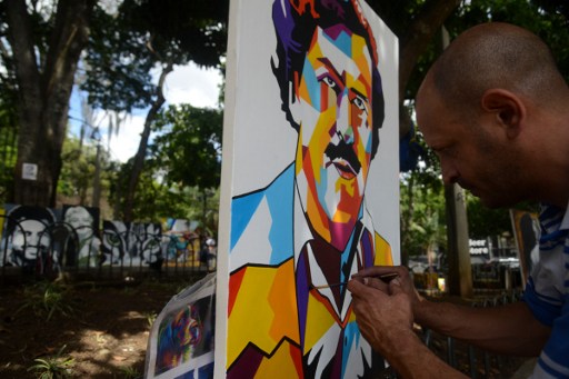 Paintings depicting late Colombian drug lord Pablo Escobar are on display at Lleras Park in  Medellin, Antioquia department, Colombia on July 21, 2016. The paintings are made by Colombian artist Wilson Rojas, who sells them by the equivalent of 120-130 dollars each. / AFP PHOTO / RAUL ARBOLEDA