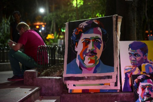 Paintings depicting late Colombian drug lord Pablo Escobar are on display at Lleras Park in  Medellin, Antioquia department, Colombia on July 21, 2016. The paintings are made by Colombian artist Wilson Rojas, who sells them by the equivalent of 120-130 dollars each. / AFP PHOTO / RAUL ARBOLEDA