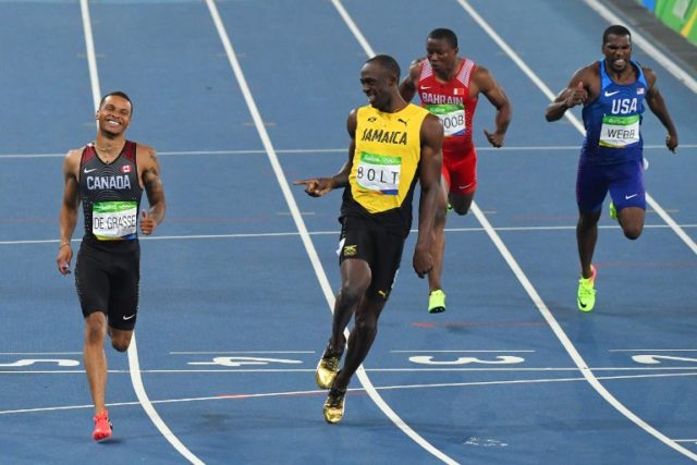 Jamaica's Usain Bolt (2ndL) laughs with Canada's Andre De Grasse after they competed in the Men's 200m Semifinal during the athletics event at the Rio 2016 Olympic Games at the Olympic Stadium in Rio de Janeiro on August 17, 2016.   / AFP PHOTO / PEDRO UGARTE