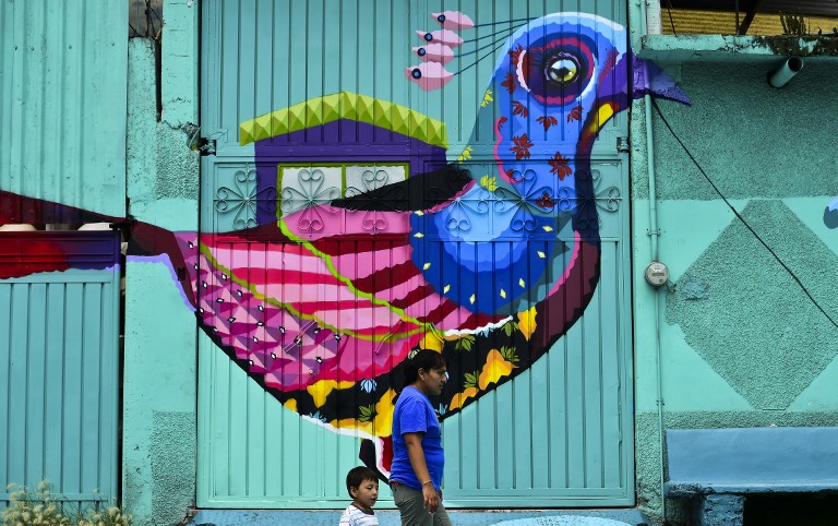View of a mural of Mexican artist Senkoe painted on a building at a poor neighborhood in Ecatepec, Mexico on August 25, 2016.  Dozens of murals were painted on buildings in a poor neighborhood in Ecatepec, on the route of a new cable car that will run this year. / AFP PHOTO / RONALDO SCHEMIDT / TO GO WITH AFP STORY BY JENNIFER GONZALEZ