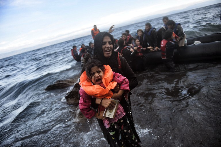 Refugees and migrants arrive at the Greek island of Lesbos after crossing the Aegean sea from Turkey on October 2, 2015. Greece