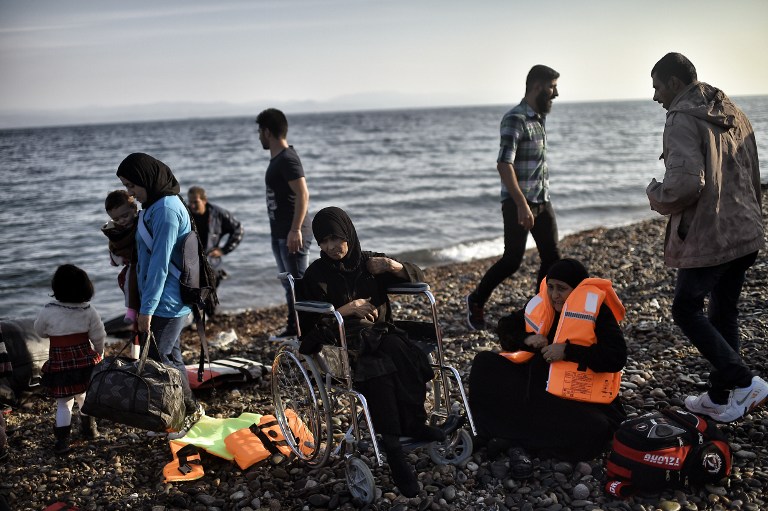 A woman in a wheelchair is pictured after reaching with other refugees and migrants aboard dinghies the Greek island of Lesbos, crossing the Aegean sea from Turkey on October 4, 2015. For the thousands of refugees and migrants landing on its beaches every day, Greece