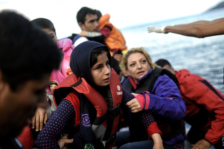 A young migrant arrives on the Greek island of Lesbos with other refugees and migrants, on October 7, 2015, after crossing the Aegean sea from Turkey. Greek premier Alexis Tsipras said on October 6 that Athens would upgrade its refugee facilities by November to tackle the growing influx from Syria as the EU pledged 600 extra staff to help. Europe is grappling with its biggest migration challenge since World War II, with the main surge coming from civil war-torn Syria. 