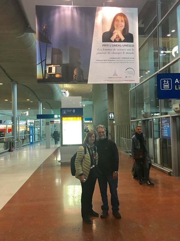 María Teresa Ruiz junto a gigantografía e su honor en Aeropuerto de París, Francia | Museo Interactivo Mirador (MIM) en Facebook