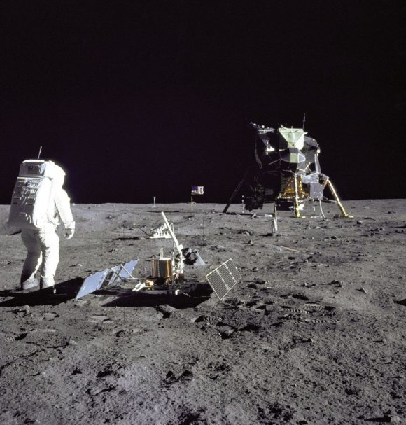 Foto del astronauta Buzz Aldrin durante una actividad extravehicular en la Luna. Hace pocos minutos había desplegado el Paquete de Experimentos Científicos de Apollo mencionado anteriormente. Al frente se puede ver el Paquete de Experimento Sísmico Pasivo y en el fondo el Retro-Reflector Láser de Distancia (LR-3).