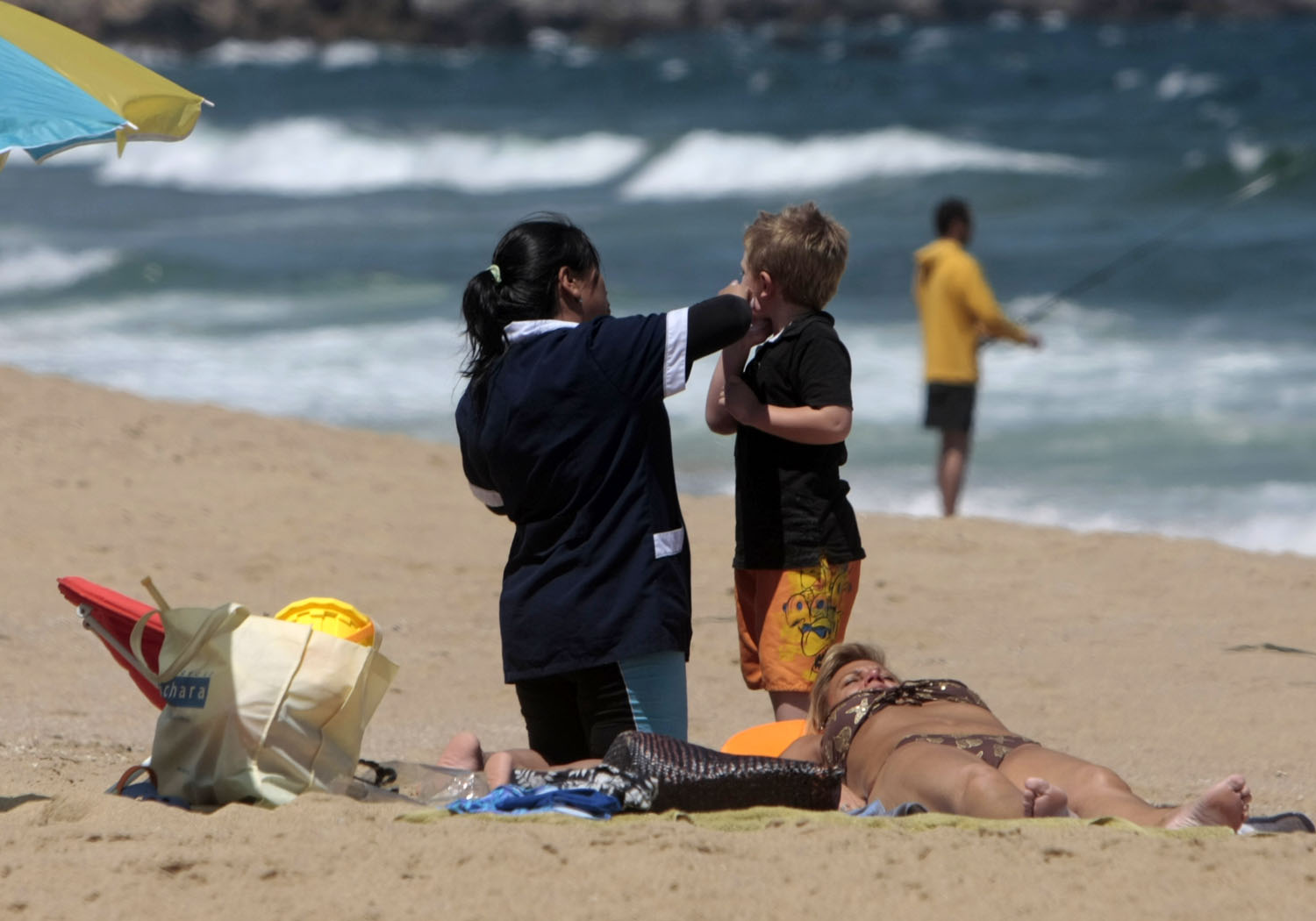 Nana cuida a niño mientras madre toma sol | Francisco O.