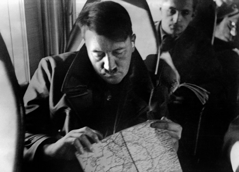 Adolf Hitler observando mapas a bordo de un avión.