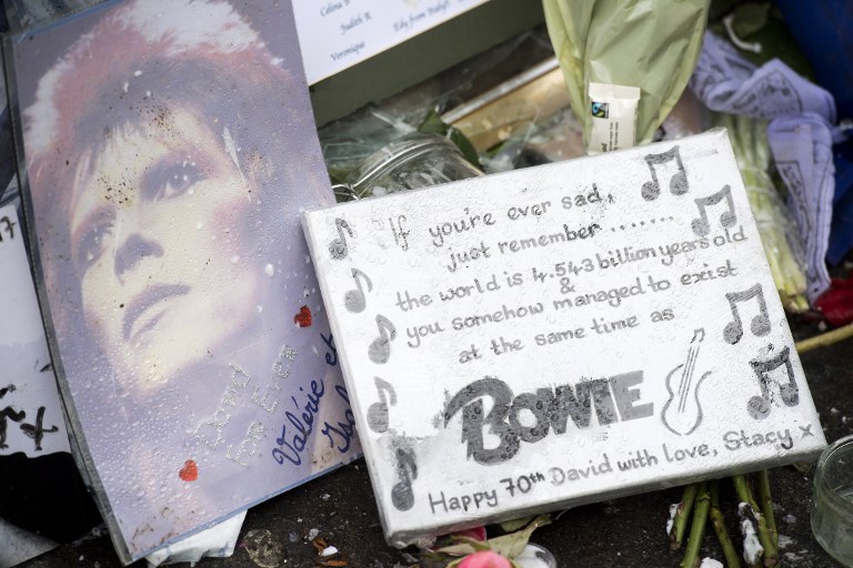 A written tribute is pictured in front of a mural of British musician David Bowie by Australian street artist James Cochran, also known as Jimmy C, in Brixton, south London on January 9, 2017, ahead of the one year anniversary of the iconic musician