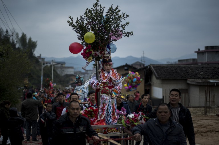 Johannes Eisele | Agencia AFP This picture taken on February 9, 2017 shows locals carrying children in palanquins during a festival as they parade through the village of Tufang in eastern China