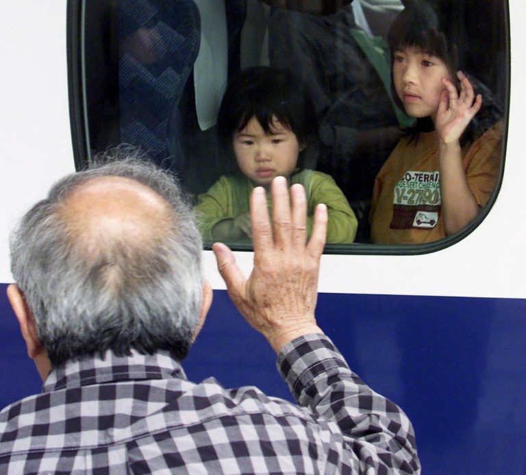 Un abuelo japonés despide a sus nietos en la estación de tren | AFP
