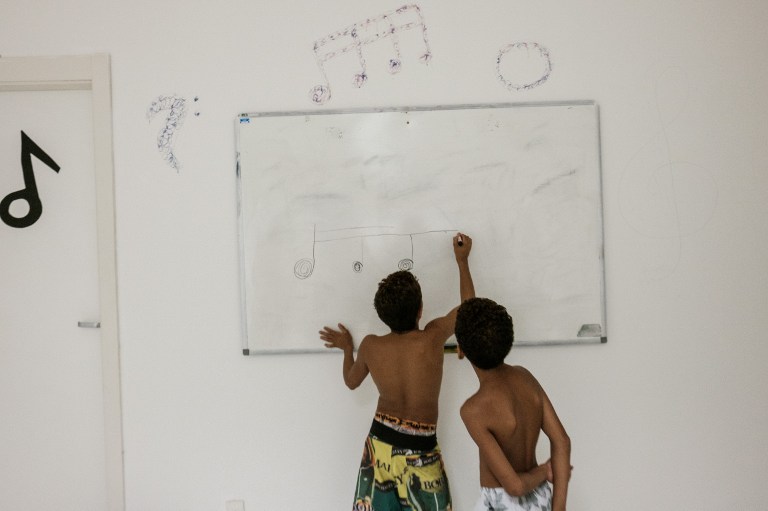 Dos niños toman una clase de música gratuita dentro de una estación del inactivo sistema de teleférico | Agencia AFP | Yasuyoshi Chiba 
