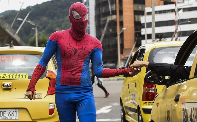 Colombian Jahn Fredy Duque, dressed as superhero "Spiderman", performs on the streets in Bogota, Colombia on April 24, 2017.  Duque hangs a white cloth 26 meters long - his "cobweb - from a bridge near the international center of Bogota, where he performs in the street for a livelihood. / AFP PHOTO / RAUL ARBOLEDA
