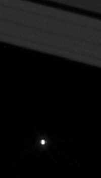 Recorte con zoom de la Tierra (el punto de luz brillante) vista entre los anillos de Saturno | NASA
