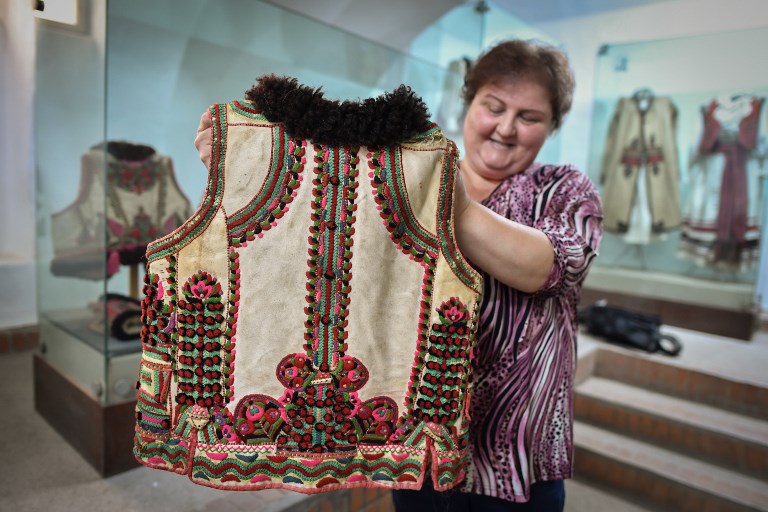 A woman working at the local museum shows a 100 years-old traditional outfit from the Bihor northwestern region of Romania in Beius, Romania on July 17, 2018.  Chaleco  Bihor |  Daniel Mihailescu | Agence France Presse 