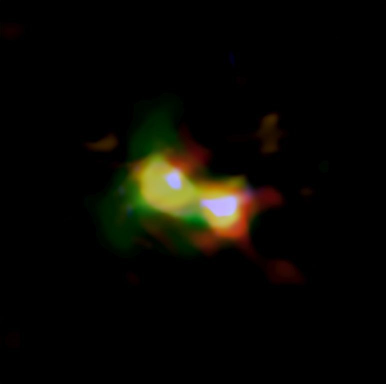Imagen compuesta de B14-65666 donde se aprecia la distribución del polvo (rojo), el oxígeno (verde) y el carbono (azul) observados por ALMA y las estrellas (blanco) observadas por el telescopio espacial Hubble | ALMA