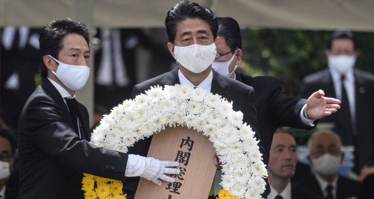 Shinzo Abe carga una ofrenda floral durante el evento oficial en el Parque de la Paz. Philip Fong | Agence France-Presse