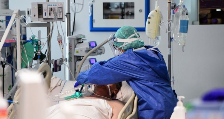 A medical worker wearing a face make and protection gear tends to a patient inside the new coronavirus intensive care unit of the Brescia Poliambulanza hospital, Lombardy, on March 17, 2020. (Photo by Piero CRUCIATTI / AFP)