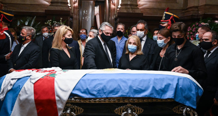 Handout picture released by the Argentine Senate showing Argentine President Alberto Fernandez (C), his partner Fabiola Yanez (2-L), Zulema Menem (3-R), her mother Zulema Yoma and his elder son Luca Bertoldi Menem standing around the coffin with the remains late former Argentine president (1989-1999) and senator Carlos Saul Menem, as he lies in state at the Congress for the wake in Buenos Aires on February 14, 2021. – Argentina’s former president Carlos Menem, who marked his country with a neoliberal approach to the economy, died in a Buenos Aires clinic on February 14, 2021 at the age of 90. Menem had been in poor health and was hospitalized several times in recent months for pneumonia. (Photo by Charly DIAZ AZCUE / ARGENTINA’S SENATE / AFP) / RESTRICTED TO EDITORIAL USE – MANDATORY CREDIT “AFP PHOTO / ARGENTINA’S SENATE / CHARLY DIAZ AZCUE” – NO MARKETING – NO ADVERTISING CAMPAIGNS – DISTRIBUTED AS A SERVICE TO CLIENTS