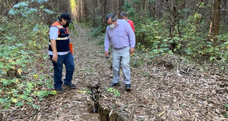 Hombres mirando una grieta.