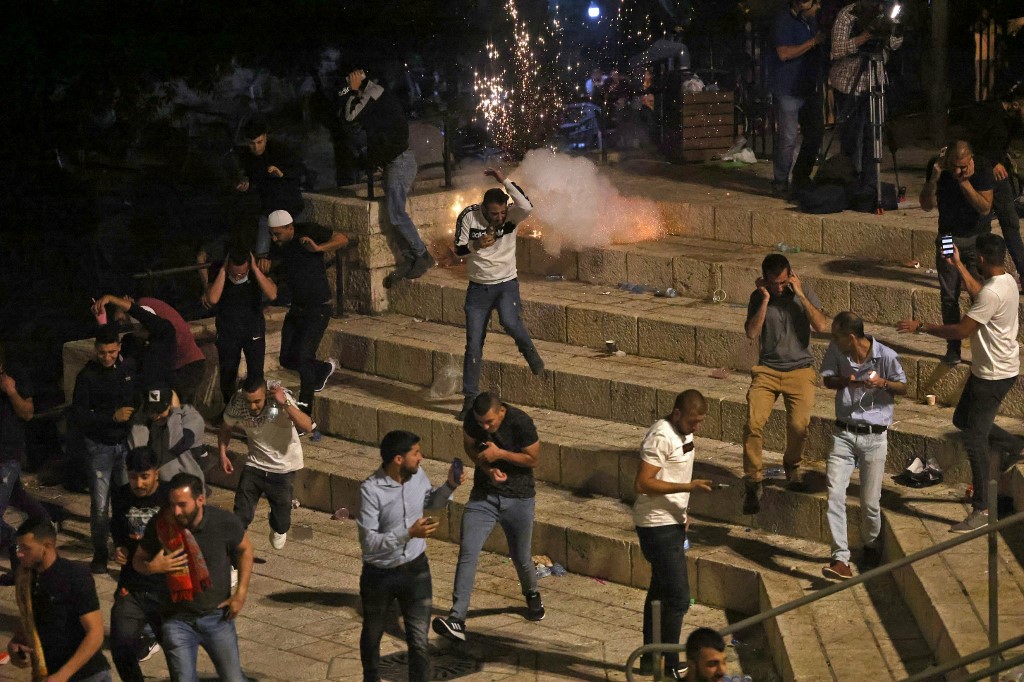 Manifestantes palestinos corren de granadas aturdidoras lanzadas por las fuerzas de seguridad israelíes – 8 de mayo | Emmanuel Dunand | AFP