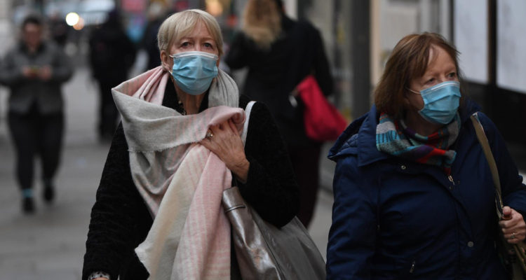 Mujeres usando mascarilla en Reino Unido luego de saberse de contagios con la variante Ómicron
