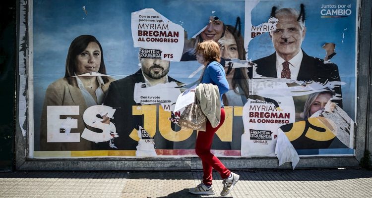 Una mujer camina frente a un cartel de publicidad alusiva a la coalición política Juntos Por el Cambio en Buenos Aires. Argentina inició las elecciones legislativas este domingo, unos comicios que renovarán la mitad de los escaños del Congreso y un tercio de las bancas del Senado.