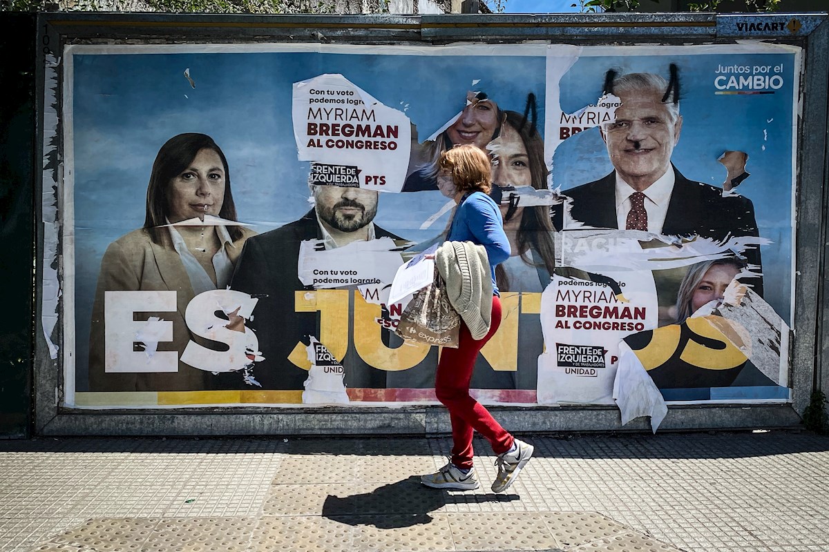 Una mujer camina frente a un cartel de publicidad alusiva a la coalición política Juntos Por el Cambio en Buenos Aires. Argentina inició las elecciones legislativas este domingo, unos comicios que renovarán la mitad de los escaños del Congreso y un tercio de las bancas del Senado.