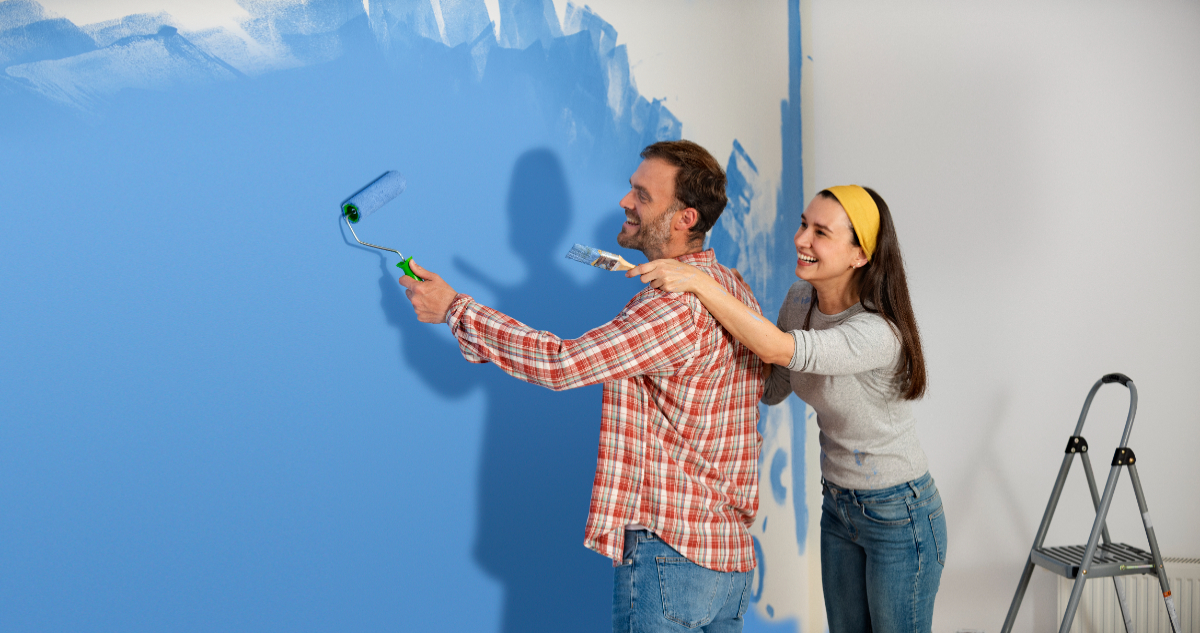 Dos personas pintando muro
