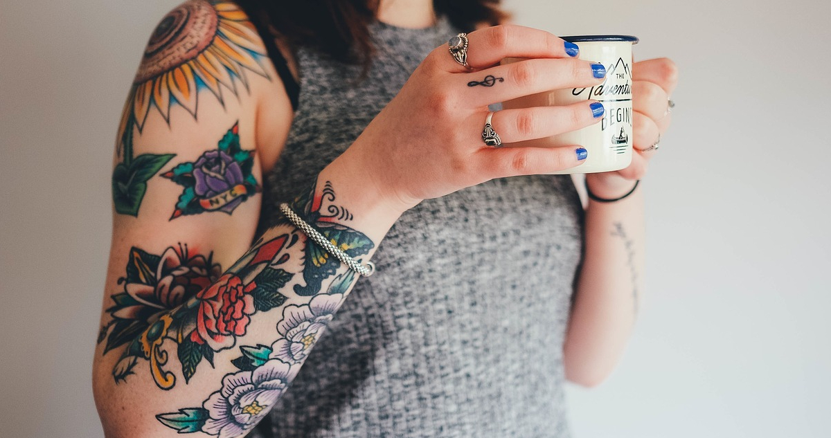 Una chica con su brazo lleno de tatuajes.
