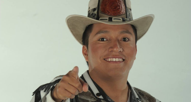 El cantante aparece con su clásico traje estilo ranchero sonriendo y apuntando a la cámara.