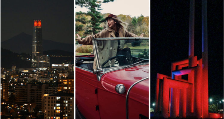 En la imagen se ve el edificio Costanera con luces rojas en su cima, a la artista en un auto rojo y una escultura iluminada en rojo en una ciudad de México
