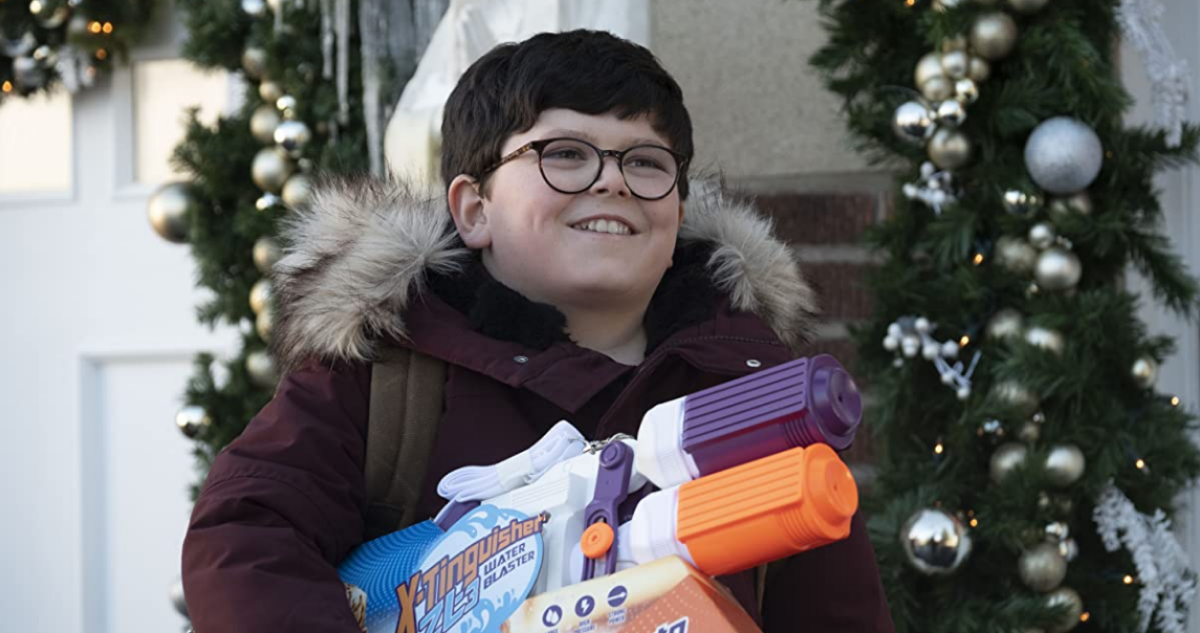 Archie Yates aparece sonriendo con ropa de nieve y una pistola de agua en sus brazos.