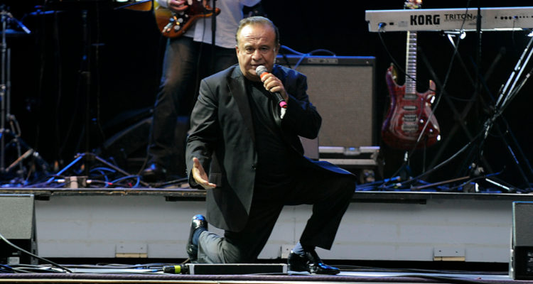 El fallecido cantante, Luis Dimas, cantando en un escenario.