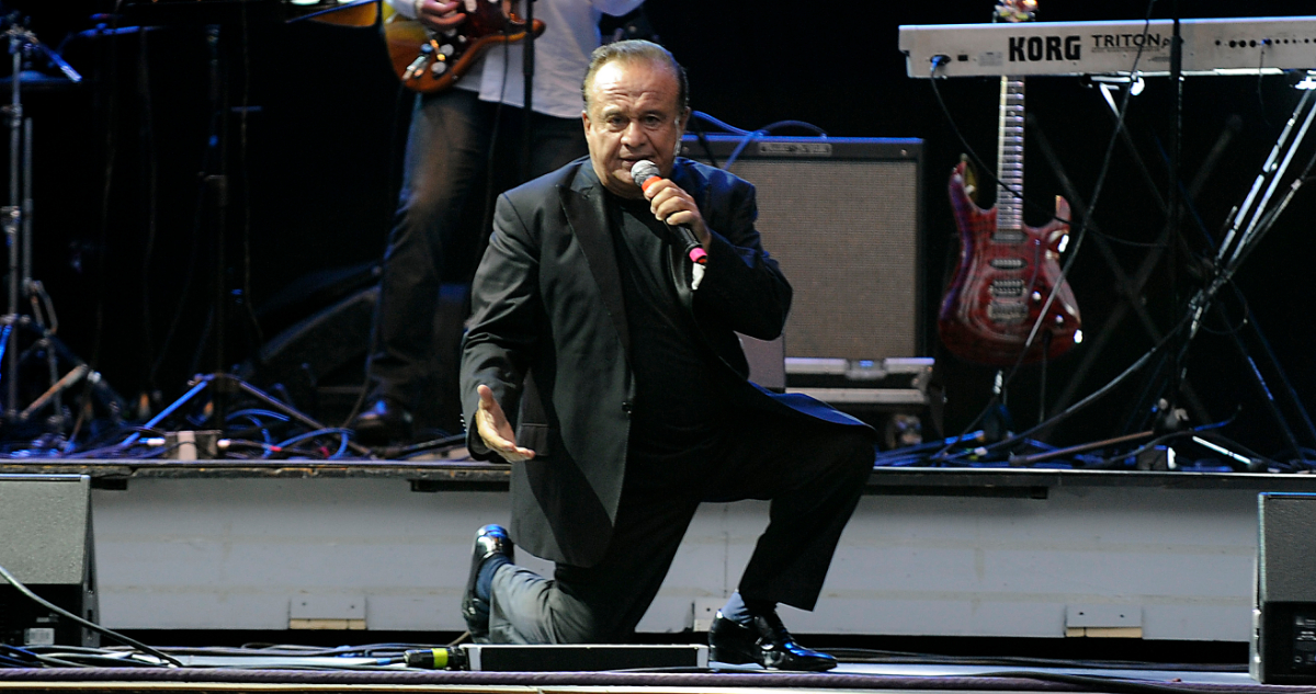 El fallecido cantante, Luis Dimas, cantando en un escenario.