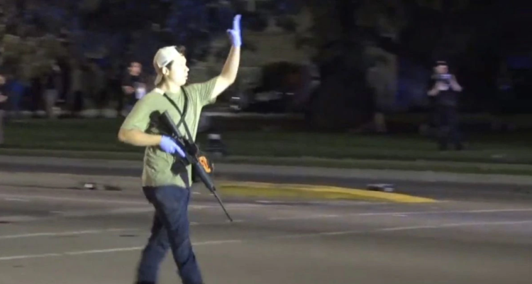 Kyle Rittenhouse caminando el día de los hechos con su fusil en mano por las calles de Kenosha.