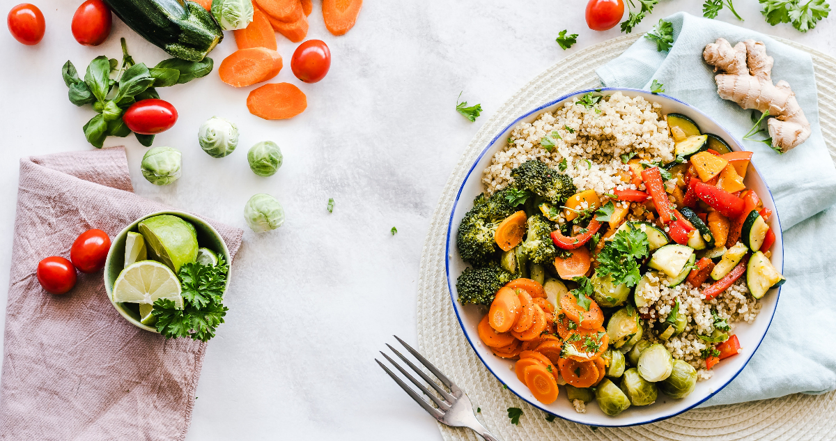 En la imagen hay un platillo lleno de verduras y quinoa sobre una mesa, donde hay restos de los ingredientes alrededor.