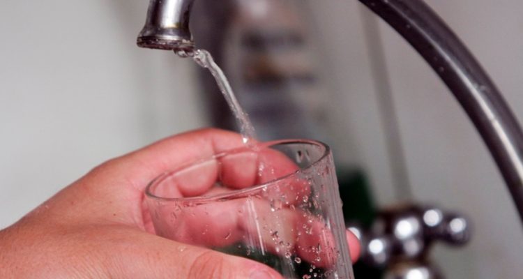 Persona llenando un vaso con agua