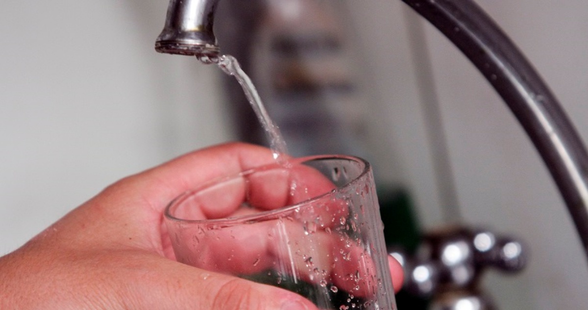 Persona llenando un vaso con agua