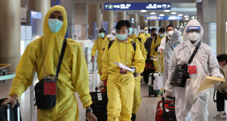 Un grupo de personas utilizando protección para evitar contagios de covid-19 y su variante Ómicron en el aeropuerto de Corea