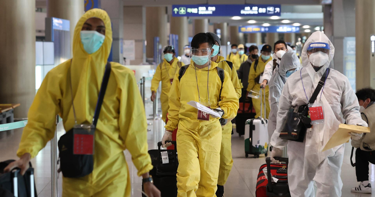 Un grupo de personas utilizando protección para evitar contagios de covid-19 y su variante Ómicron en el aeropuerto de Corea