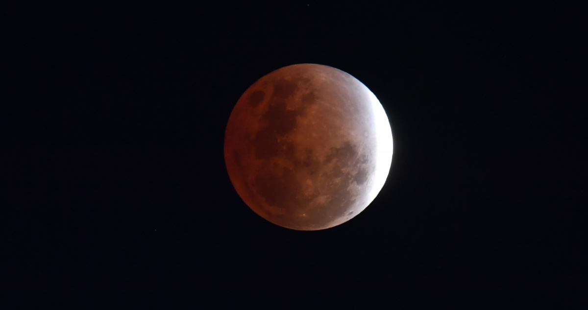 En la foto, el eclipse parcial de luna está en su punto máximo y sólo una pequeña parte del satélite está iluminada.