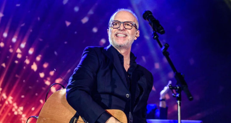 El cantante Alberto Plaza con su guitarra en medio de una presentación.