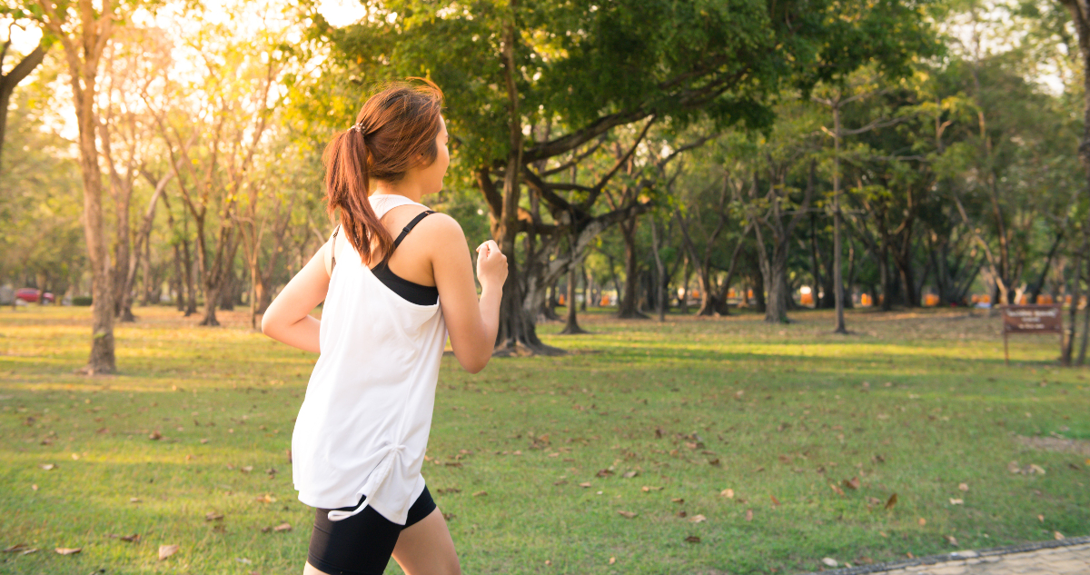 Una mujer corriendo en un parque.