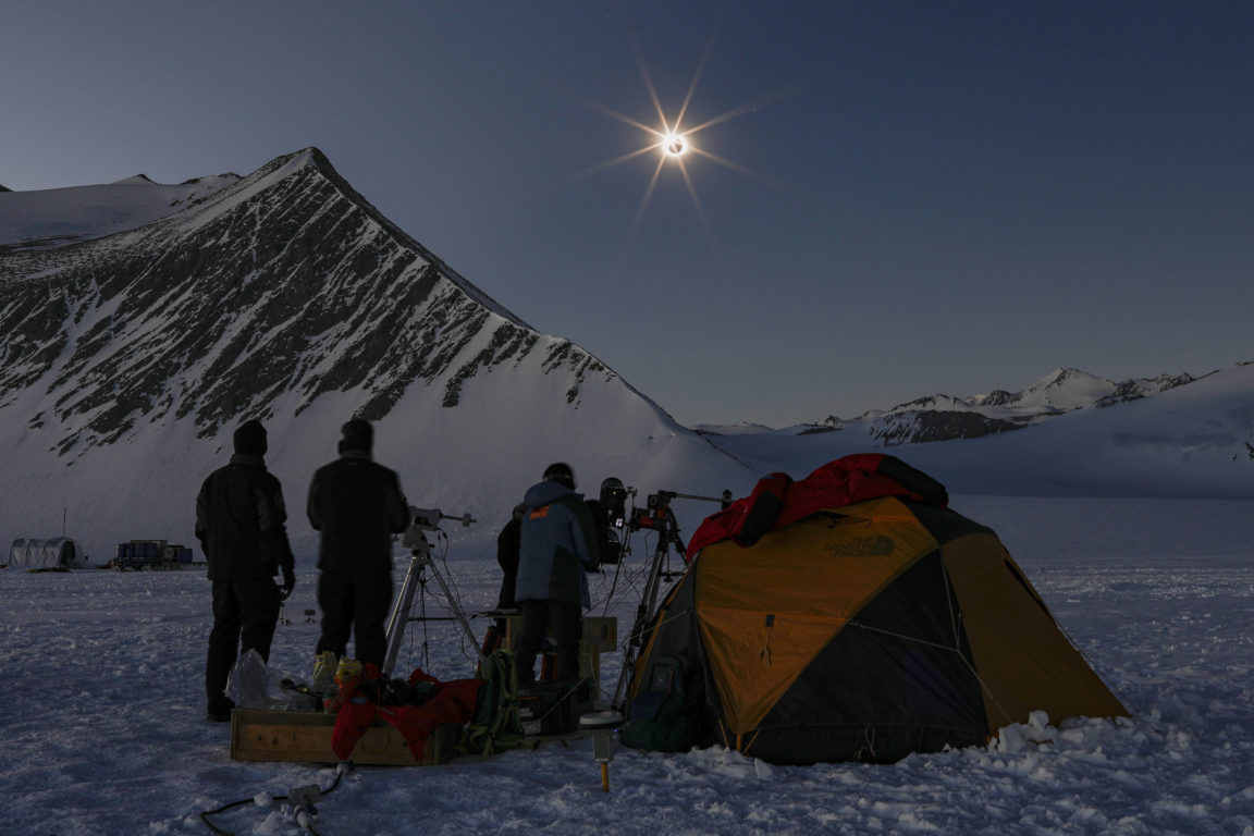 Eclipse total en la antartica, mientras fotógrafos captan el momento.