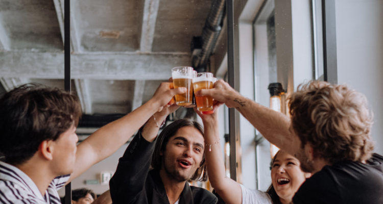 Un grupo de amigos haciendo un brindis con vasos con cerveza.